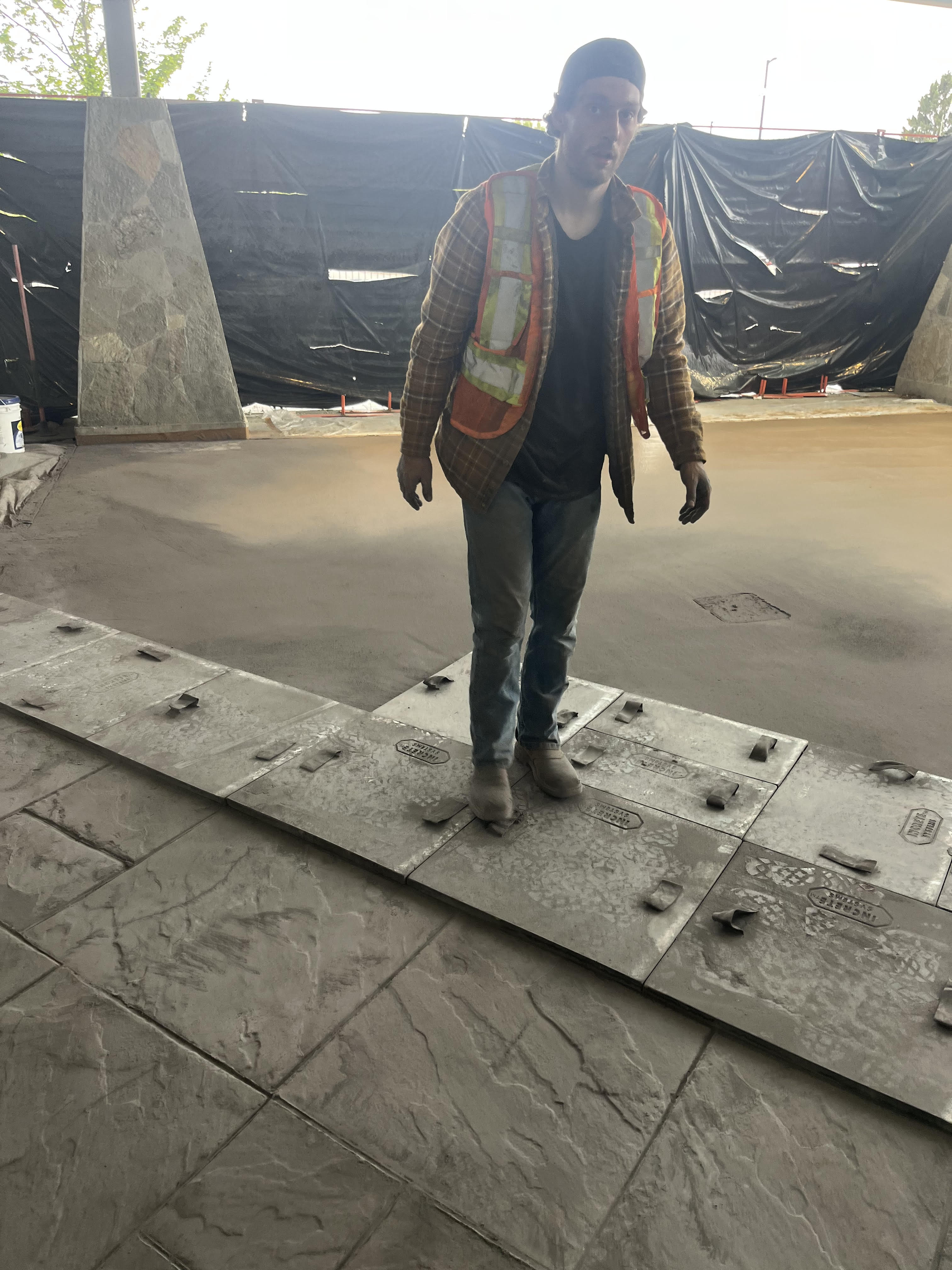 S&K tradesperson setting stamping mats into the fresh slab at Cascades Casino, Langley